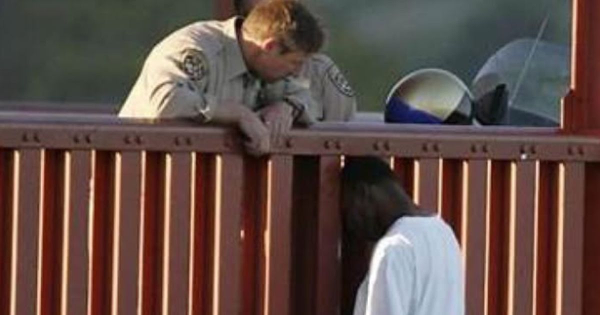 California Highway Patrol Sgt. Kevin Briggs, left, speaks to Kevin Berthia, right, who was attempting to commit suicide by jumping off of the Golden Gate Bridge in March 2005.