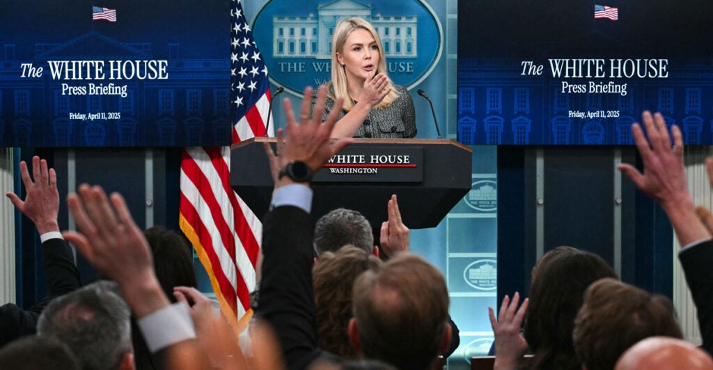 White House press secretary Karoline Leavitt takes questions in the White House press briefing room with reporters raising hands with questions