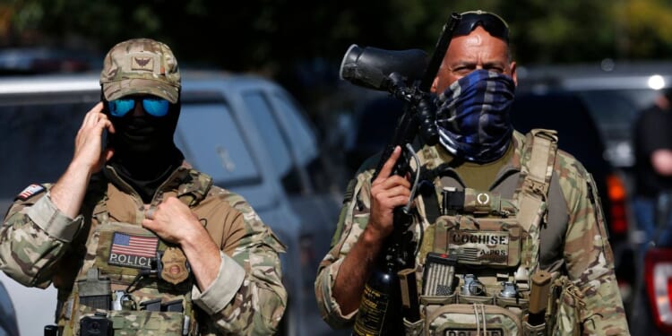 A masked U.S. Customs and Border Protection agent is seen as residents of Chicago's Brighton Park neighborhood confront law enforcement at a gas station after Immigration and Customs Enforcement agents allegedly detained an unidentified man riding in his car, in Chicago, Illinois, on Oct. 4, 2025.