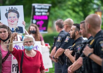 Police officers look on as abortion rights advocates hold a demonstration outside the home of U.S. Supreme Court Justice Brett Kavanaugh on May 18, 2022, in Chevy Chase, Maryland.