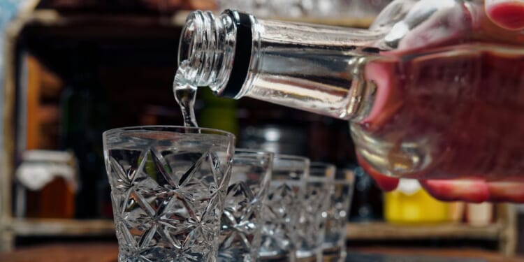 Crystal shot glasses of vodka standing in a row.