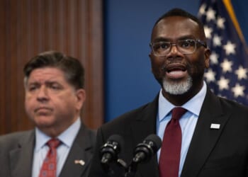 Illinois Gov. J.B. Pritzker listens as Chicago Mayor Brandon Johnson speaks at a news conference on Oct. 6, 2025, in Chicago, Illinois.