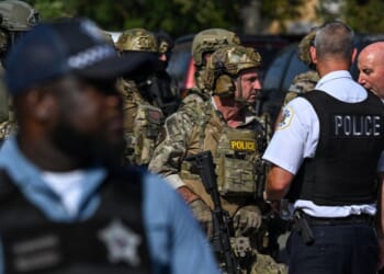 Chicago police officers speak with federal agents in Chicago, Illinois, on Oct. 4, 2025.