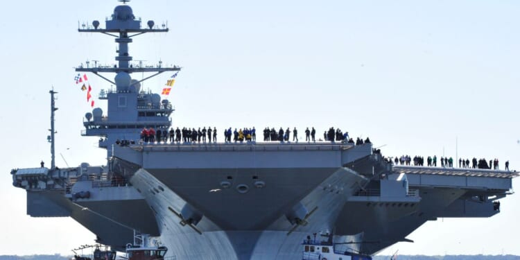 In this handout photo provided by the U.S. Navy, sailors aboard the aircraft carrier Pre-Commissioning Unit Gerald R. Ford man the rails as the ship departs Huntington Ingalls Industries Newport News Shipbuilding for builder's sea trials off the U.S. East Coast on April 8, 2017, in Newport News, Virginia.