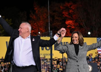 Vice President and Democratic presidential candidate Kamala Harris, right, and her vice presidential running mate Minnesota Gov. Tim Walz greet supporters during a campaign rally in Ann Arbor, Michigan, Oct. 28, 2024.