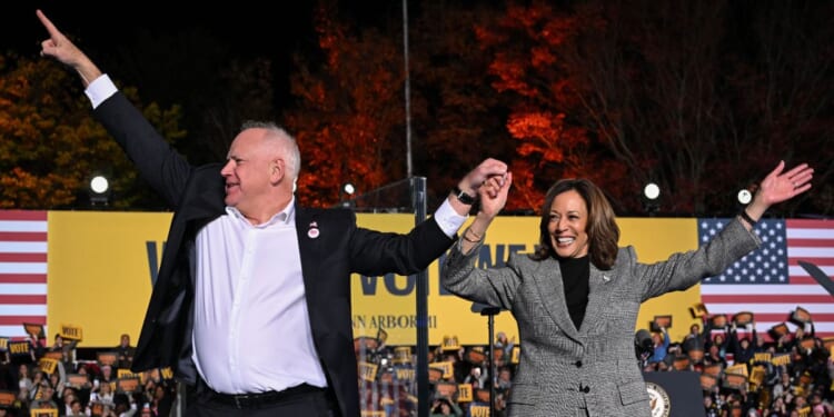 Vice President and Democratic presidential candidate Kamala Harris, right, and her vice presidential running mate Minnesota Gov. Tim Walz greet supporters during a campaign rally in Ann Arbor, Michigan, Oct. 28, 2024.