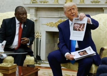 President Donald Trump holds up a printed article from "American Thinker" while accusing South Africa President Cyril Ramaphosa of state-sanctioned violence against white farmers in South Africa during a press availability in the Oval Office at the White House on May 21, 2025, in Washington, D.C.