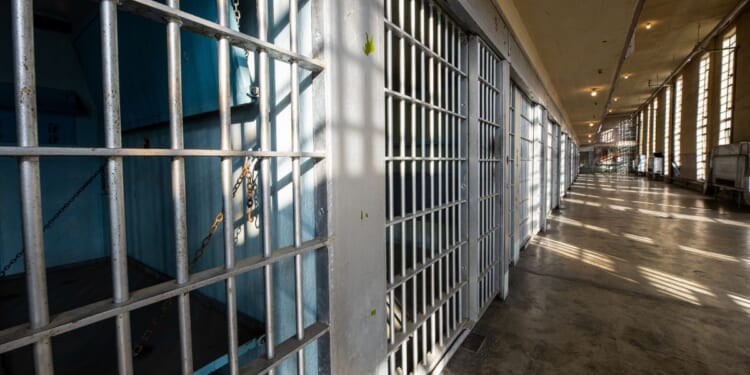 The sun shines on the bars in a prison.