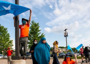 People hold up Somali flags during a protest calling for justice for Isak Aden on July 1, 2020 in Eagan, Minnesota. Isak Aden was killed on July 2, 2019 after a standoff with Eagan Police. No charges were brought against the officers involved in his death.