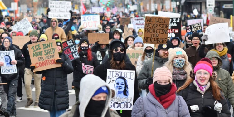 Protesters hold signs Saturday as they march from Powderhorn Park in Minneapolis against Immigration and Customs Enforcement and the fatal shooting of Renee Good by an ICE agent, calling on federal authorities to leave the city.