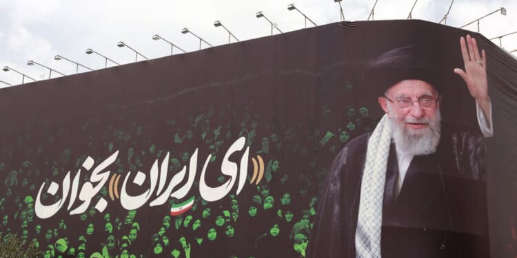 This picture shows a billboard bearing the portrait of Iranian supreme leader Ayatollah Ali Khamenei and a quote reads in Persian "Sing Oh Iran" at the Enqelab Square in Tehran on July 9, 2025.