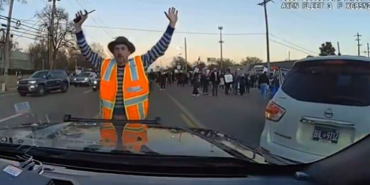 An anti-ICE protester stands in front of a police car in Memphis, Tennessee, on Jan. 11, 2026.