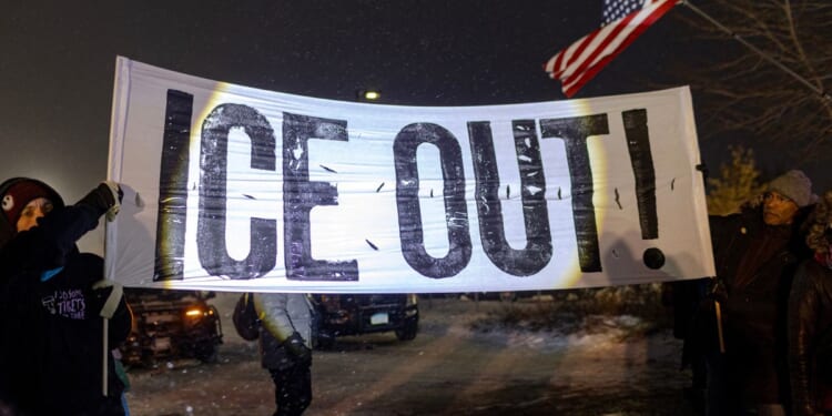 Protesters hold a large anti-ICE sign in Minneapolis, Minnesota on Jan. 18, 2026.