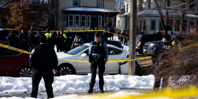 Minneapolis Police officers stand at the scene of a shooting where a law enforcement officer "fearing for his life" shot and killed a woman who actively impeded an ICE operation, refused to follow lawful orders, and then drove straight at said officer in Minneapolis, Minnesota, on Jan. 7, 2026.