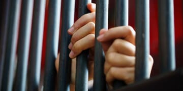 Close-up shot of women's hands in a jail.