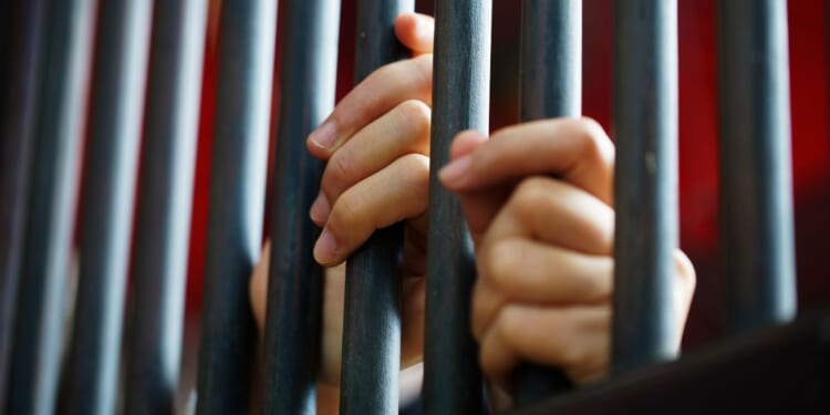 Close-up shot of women's hands in a jail.