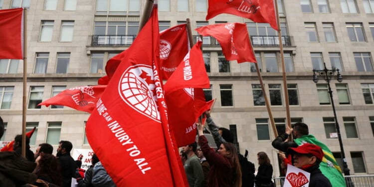 Members of the Democratic Socialists of America gather outside of a Trump-owned building on May Day on May 1, 2019, in New York City.