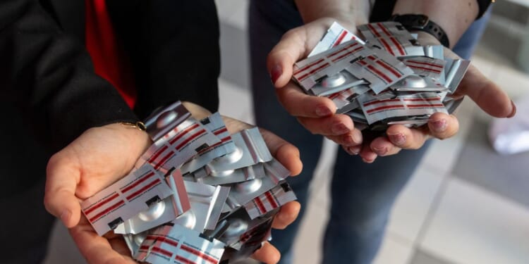 Polish pro-abortion activist Justyna Wydrzynska of the "Abortion Dream Team" women's rights group and Manon Aubry from La France Insoumise present abortion pills donated by representatives of LFI for Poland's first activist-run abortion consultation point in Warsaw, Poland, on April 29, 2025.