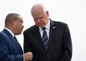 Minnesota Attorney General Keith Ellison and Minnesota Governor Tim Walz await the arrival of Vice President Kamala Harris at the Minneapolis-St. Paul International Airport in Saint Paul, Minnesota, on March 14, 2024.