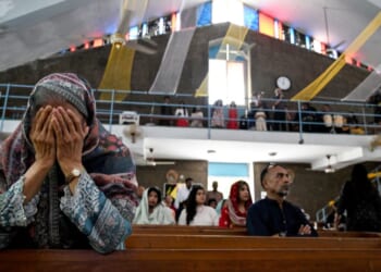 Christian attendees of a church in Islamabad pray on April 20, 2025.