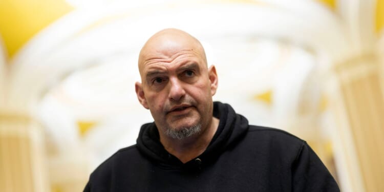 Sen. John Fetterman speaks to reporters as he leaves the Senate Chamber at the U.S. Capitol on Jan. 29, 2026, in Washington, D.C.