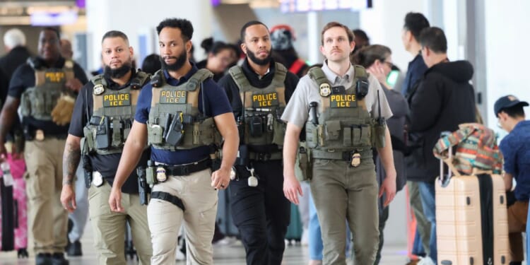 Federal law enforcement agents, including some with U.S. Immigration and Customs Enforcement, walk through LaGuardia Airport in New York on March 23, 2026.