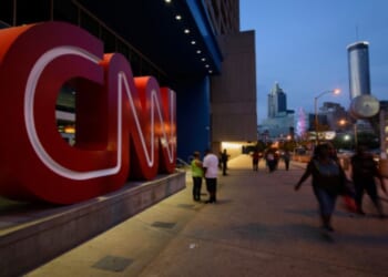 People walk past the CNN Headquarters in Atlanta, Georgia, on Aug. 2, 2014.