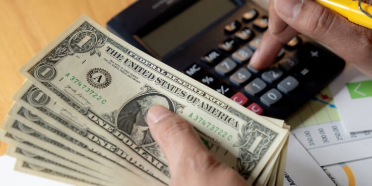 A man does some financial planning on a desk.