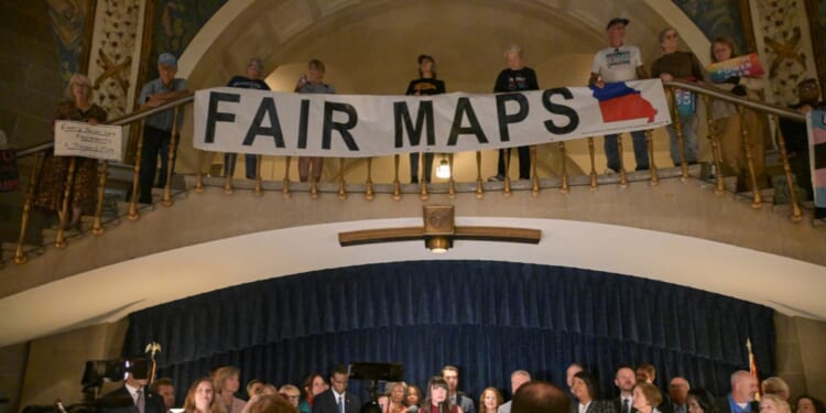 Activists display signs during a press conference inside the rotunda of the Missouri State Capitol Building on Sept. 10, 2025, in Jefferson City, Missouri.