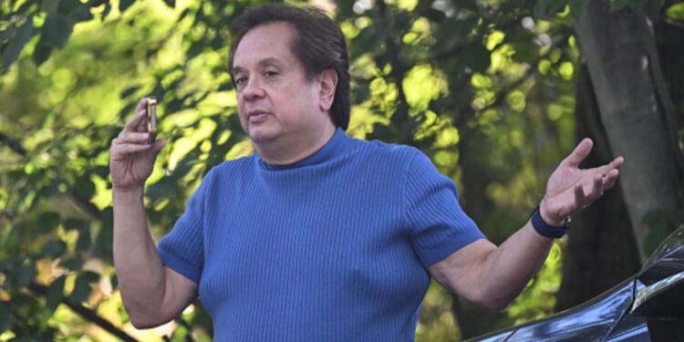 George Conway speaks on the phone outside John Bolton’s Bethesda, Maryland home as raid takes place on August 22, 2025.