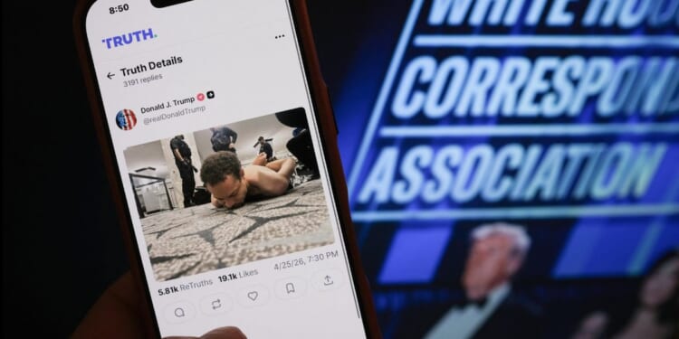 A hand holds a phone with a photo of Cole Tomas Allen, the man accused of attempting to murder President Donald Trump and other administration officials. at the White House Correspondents' dinner on April 25, 2026 in Washington, DC.