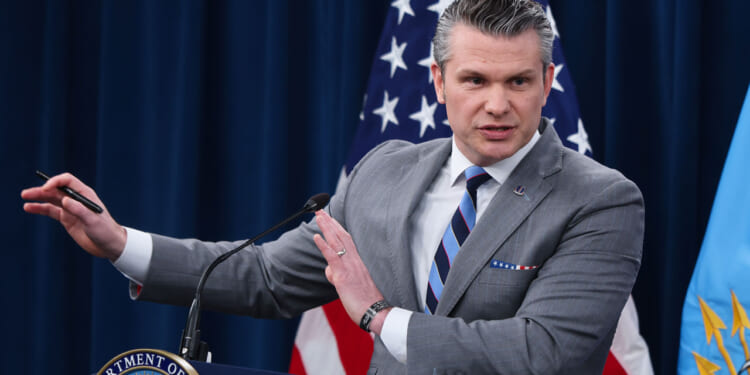 Secretary of War Pete Hegseth speaks to reporters in the Pentagon.