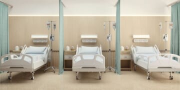 A hospital room with three beds and wooden decoration.