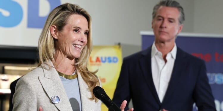 California Governor Gavin Newsom looks on as his wife Jennifer Siebel Newsom speaks at Belvedere Middle School in Los Angeles on Oct. 8, 2025.