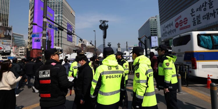 South Korean police officers patrol near the concert venue ahead of the comeback concert of K-pop boy band BTS at Gwanghwamun Square on March 21, 2026, in Seoul, South Korea.