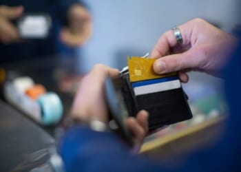 Man pulls card out of wallet.