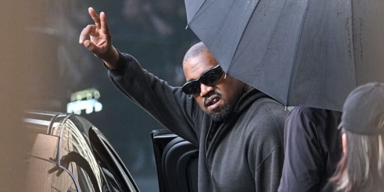U.S. rapper and producer Kanye West gestures upon arriving at Shanghai Pudong International Airport on July 11.