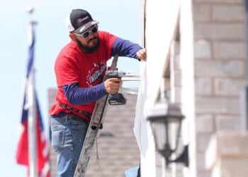 A worker installs a window on a house under construction in Richardson, Texas, on March 23, 2026.