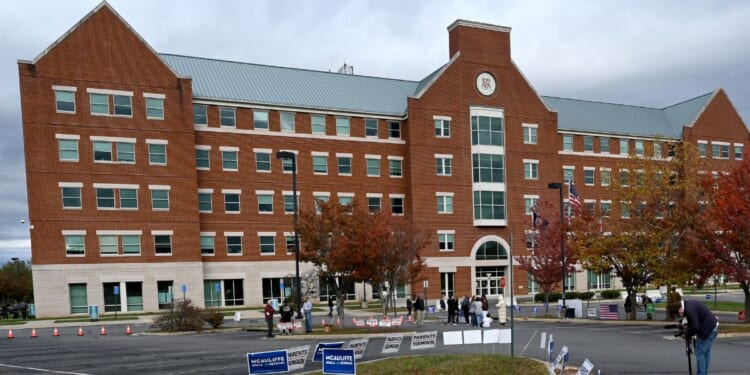 Students, parents, and others hold signs outside the Loudoun County school board meeting on Oct. 26, 2021, in Ashburn, Virginia.