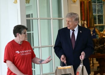 President Donald Trump speaks with a DoorDash delivery worker after she delivered McDonald's at the Oval Office at the White House in Washington, D.C., on April 13, 2026.