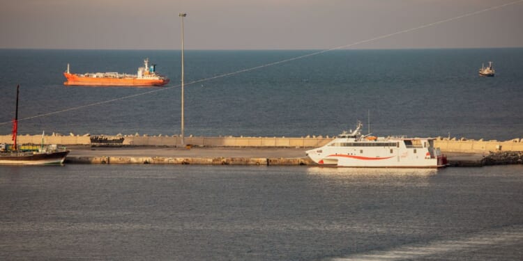 A police speed boat patrols the port as oil tankers and high speed crafts sit anchored at Muscat Anchorage near the Strait of Hormuz on March 30, 2026, in Muscat, Oman.