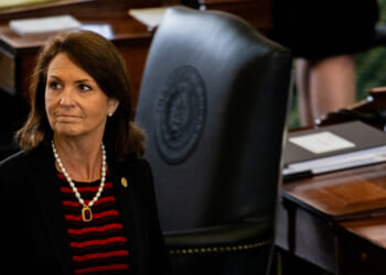 Angela Paxton looks on