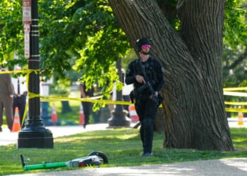 A U.S. Secret Service officer protects the crime scene following an exchange of gunfire Monday between Secret Service and a gunman on the National Mall in Washington, D.C. Police say a gunman shot at a Secret Service agent and wounded a bystander before being shot by police.