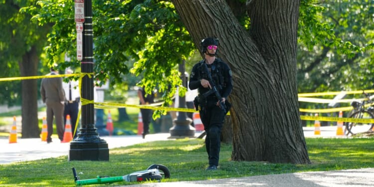 A U.S. Secret Service officer protects the crime scene following an exchange of gunfire Monday between Secret Service and a gunman on the National Mall in Washington, D.C. Police say a gunman shot at a Secret Service agent and wounded a bystander before being shot by police.