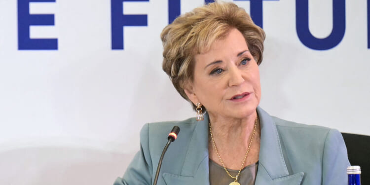 Linda McMahon looks on.