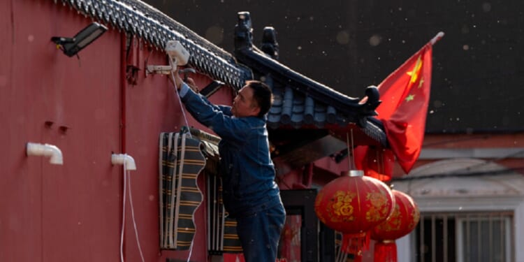 A man sets up a surveillance camera outside a restaurant with a Chinese national flag in Beijing on Friday as the capital city prepared for President Donald Trump's arrival.