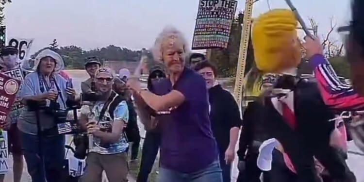 The woman's shirt bore a message about kindness and doing unto others as you would have them do unto you. Then someone put a stick in her hand and held out an effigy of President Donald Trump.