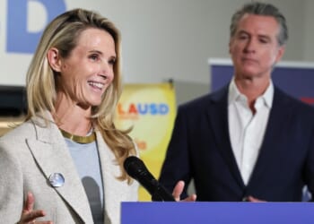 Governor Gavin Newsom looks on as his wife Jennifer Siebel Newsom speaks.