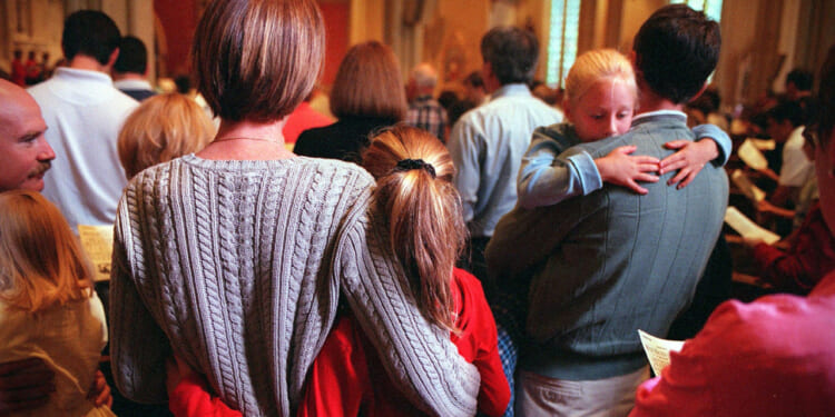 A family holds each other while attending a church service.