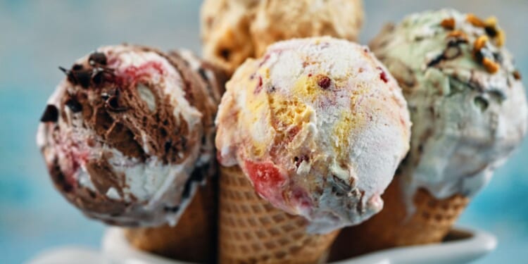 A variety of ice cream flavors in cones.